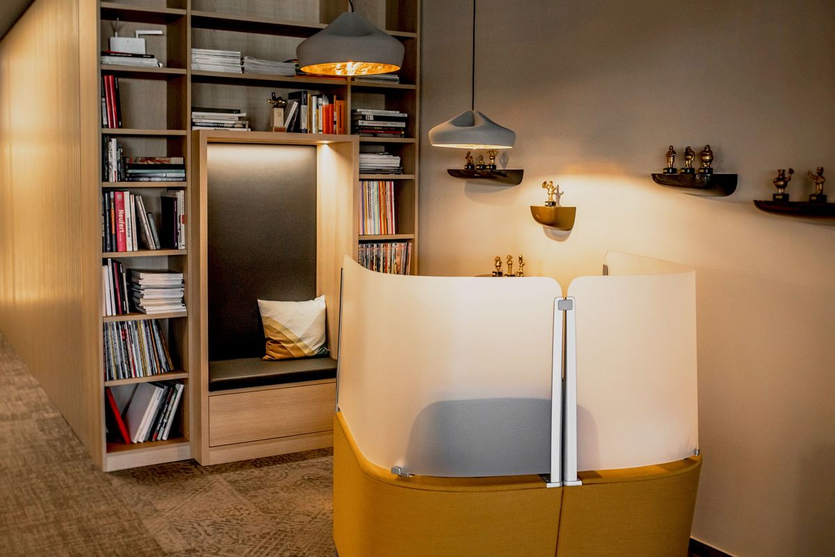 Eine moderne Büroeinrichtung mit einem Bücherregal und einer Lampe.